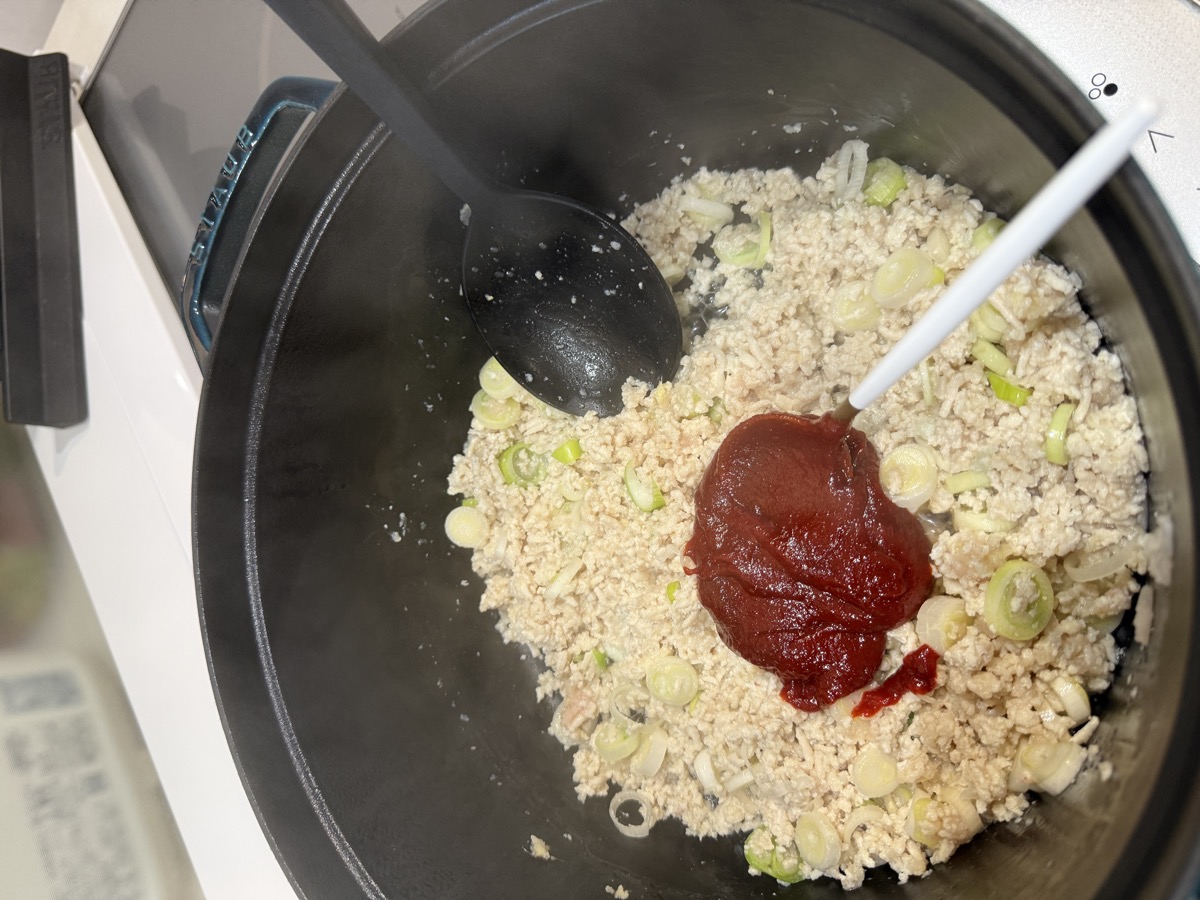 Sautéing diced onions and ground chicken with generous grated ginger, garlic, and gochujang