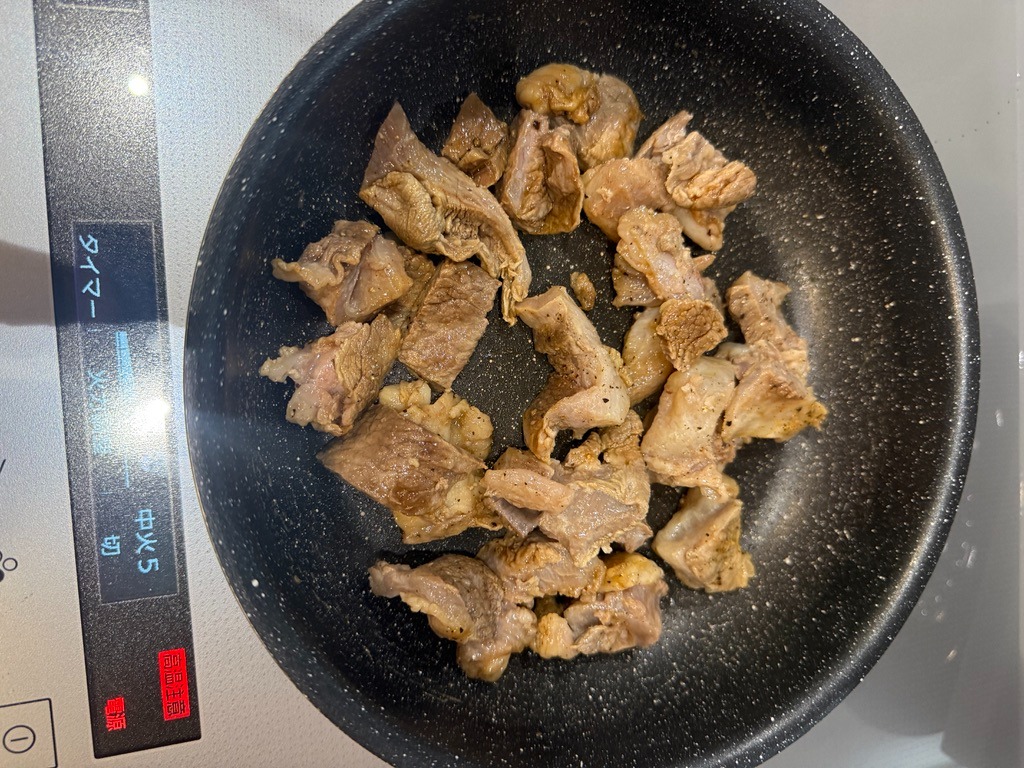 フライパンで黒毛和牛すじ肉を塩コショウで香ばしく炒める様子