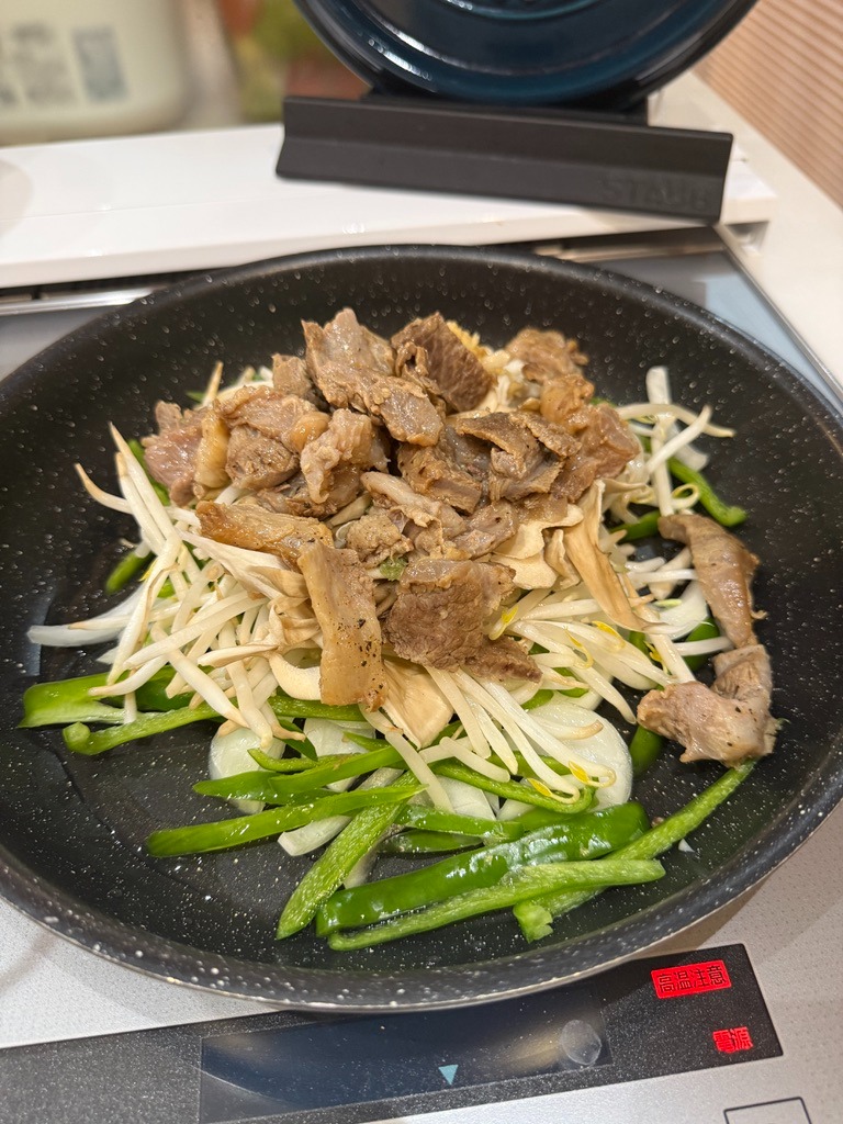 フライパンで黒毛和牛すじ肉とたっぷり野菜をオイスターソースで炒め合わせる様子